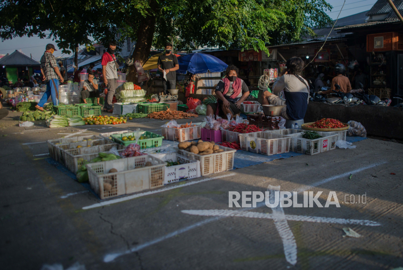 Sejumlah pedagang menerapkan jarak fisik saat berjualan di Pasar Perumnas Klender, Jakarta, Selasa (16/6). PT Bank Mandiri (Persero) Tbk memprediksi pertumbuhan ekonomi Indonesia minus 3,4 persen pada kuartal dua 2020.