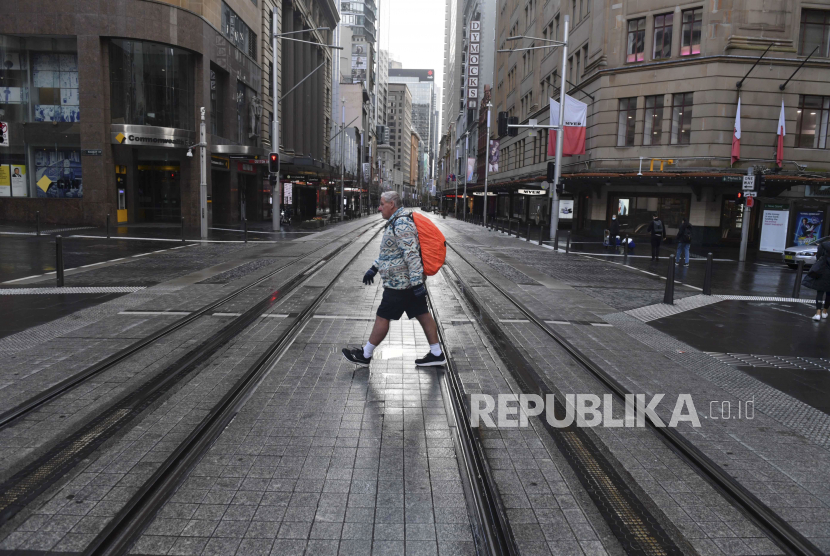 Seorang pria melewati jalanan yang sepi di kawasan pusat bisnis Sydney, Australia, Selasa (29/6). 