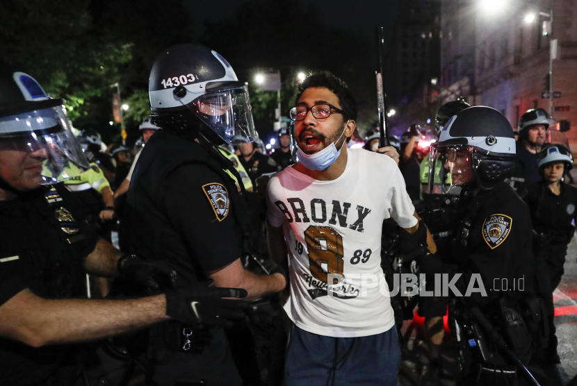 Seorang pengunjuk rasa ditangkap di Fifth Avenue oleh petugas kepolisian Kota New York saat pawai Kamis, 4 Juni 2020, di wilayah Manhattan, New York. Unjuk rasa terkiat kasus Flyod juga digelar warga di Mexico City, Meksiko pada Jumat (5/6).