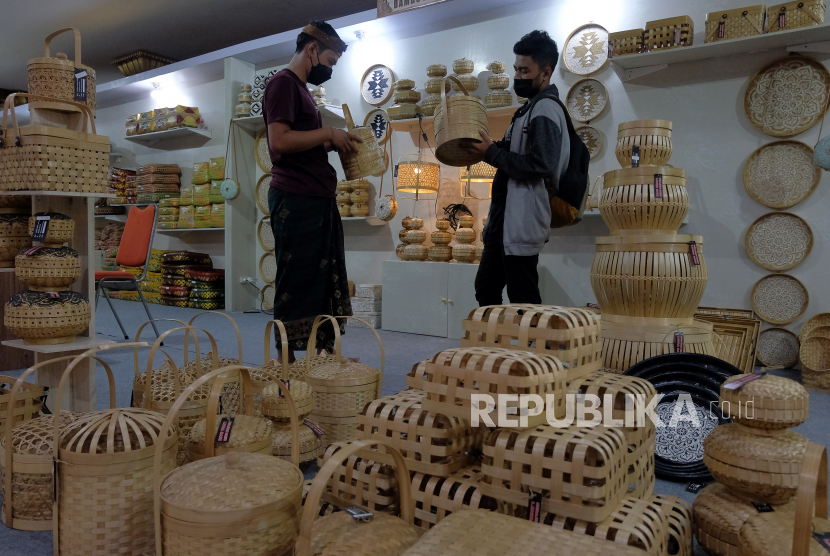 Pedagang melayani calon pembeli yang memilih kerajinan berbahan bambu pada pameran industri kecil menengah (IKM). ilustrasi