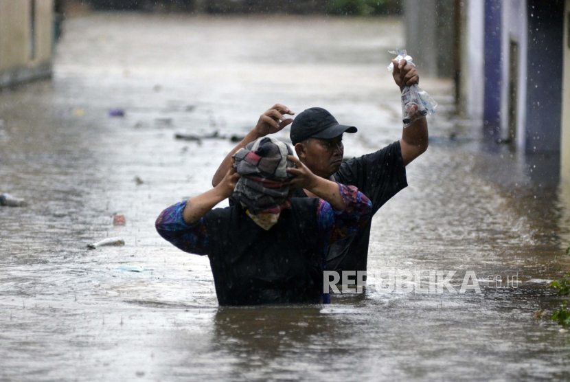 Warga melintasi banjir (ilustrasi). BMKG Lampung mencatat dua kabupaten sudah memasuki periode musim hujan dengan curah hujan tinggi. 