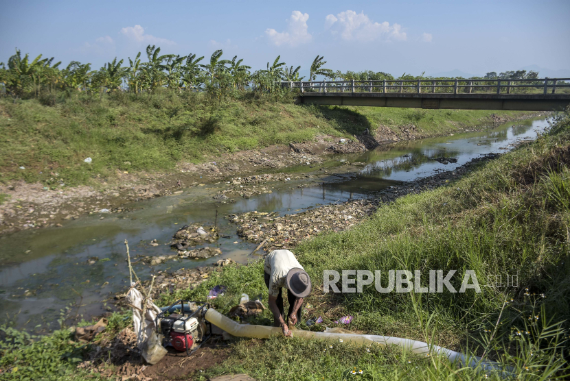 Petani mengoperasikan mesin pompa air di Sungai Cikeruh yang mulai mengering di Tegalluar, Kabupaten Bandung, Jawa Barat, Jumat (4/8/2023). 
