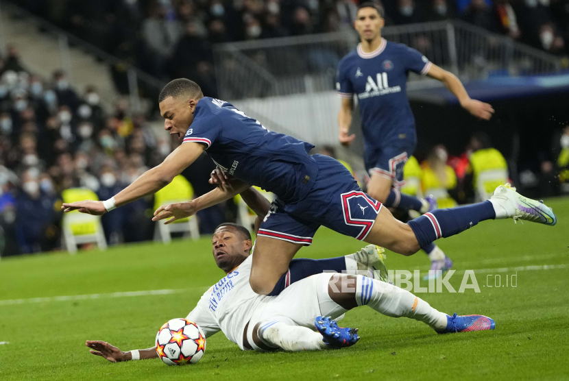 Kylian Mbappe dari PSG, atas, dan David Alaba dari Real Madrid berebut bola selama pertandingan sepak bola leg kedua babak 16 besar Liga Champions antara Real Madrid dan Paris Saint-Germain di stadion Santiago Bernabeu di Madrid, Spanyol, Rabu, 9 Maret , 2022.