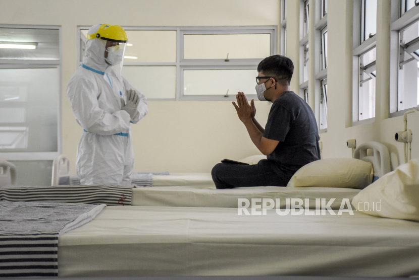 Petugas kesehatan berbincang dengan warga saat simulasi penanganan pasien Covid-19 di tempat isolasi terpadu di Gedung Akademi Keperawatan Kebon Jati, Jalan Kawaluyaan, Kota Bandung, Senin (21/2/2022). Kulit membiru saat kena Covid-19 merupakan salah satu gejala parah yang membutuhkan perhatian medis darurat.