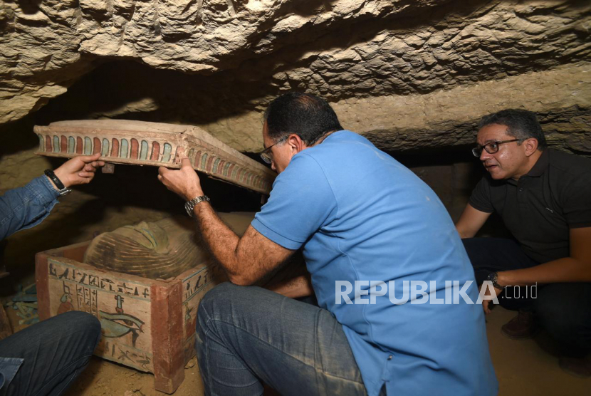 Foto selebaran tak bertanggal yang disediakan oleh Kementerian Pariwisata dan Purbakala Mesir menunjukkan Perdana Menteri Mesir Mustafa Madbouly (tengah) dan Menteri Purbakala Mesir Khaled el-Anany (kanan) melihat salah satu peti mati yang ditemukan di poros pemakaman kuno di sebuah pekuburan di Saqqara, selatan Kairo, Mesir (dikeluarkan 20 Oktober 2020). Para arkeolog menemukan poros penguburan baru di sebuah pekuburan di Saqqara yang dilaporkan berisi lebih dari 80 sarkofagus yang diyakini 2.500 tahun lalu. 