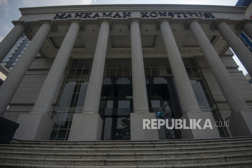 Petugas menyemprotkan cairan disinfektan di gedung Mahkamah Konstitusi (MK), Jakarta, Jumat (24/7/2020). MK menunda semua jadwal persidangan sementara waktu mulai Senin (27/7) untuk dilakukan sterilisasi guna mencegah penyebaran COVID-19. ANTARA FOTO/Aditya Pradana Putra/wsj.  *** Local Caption *** 