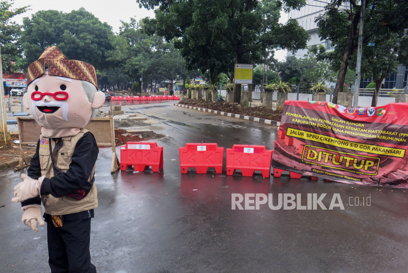 Pembatas jalan dipasang menutup Jalan Kolonel Egi Yoso Martadipura di kawasan Stadion Pakansari, Kabupaten Bogor, Jawa Barat, Minggu (24/1/2021).  Pemerintah memutuskan memperpanjang pemberlakuan pembatasan kegiatan masyarakat (PPKM) Jawa-Bali lantaran masih tingginya kasus aktif COVID-19 di beberapa daerah tersebut. Perpanjangan terhitung mulai 26 Januari hingga 8 Februari 2021. 