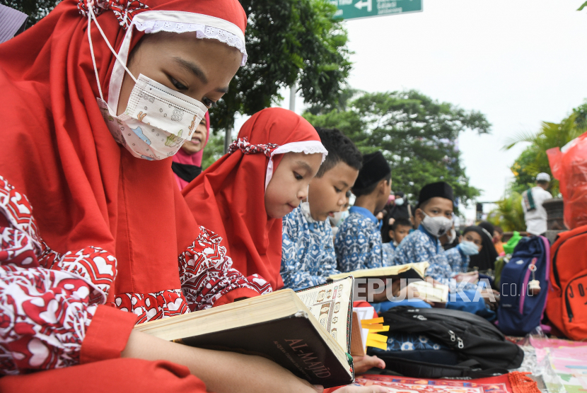 Sejumlah anak-anak membaca Al-Quran secara bersamaan dalam acara Bekasi Mengaji di pedestrian Jalan Ahmad Yani, Bekasi, Jawa Barat, Rabu (27/4/2022). Acara yang diikuti 1.300 jamaah tersebut untuk mempererat tali ukuwah Islamiyah.Keluarga Sakinah Lahirkan Generasi Muslim Unggul 