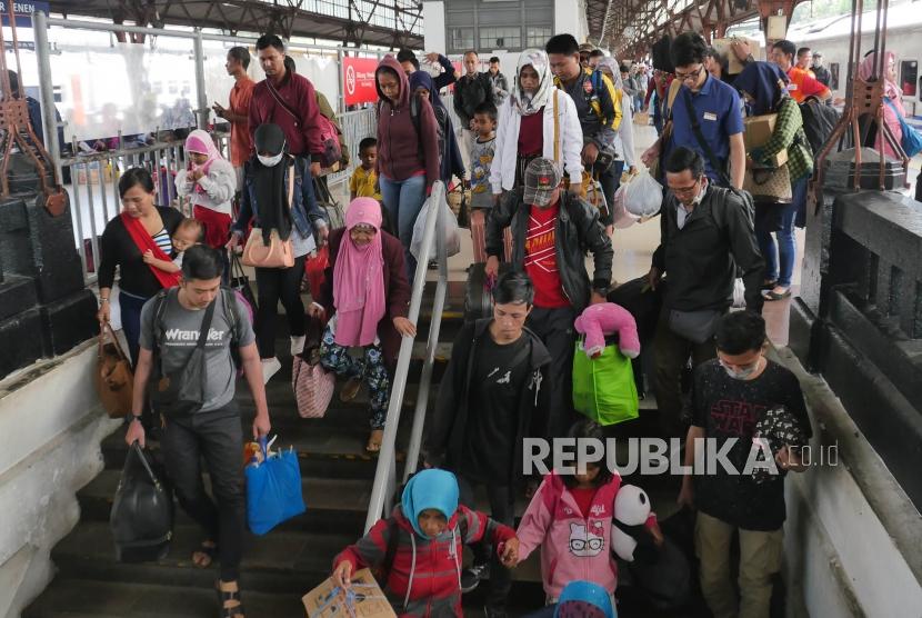 Penumpang kereta api Jayabaru  menuruni tangga pintu keluar di stasiun Kereta api Senen Jakarta, Kamis (21/2).