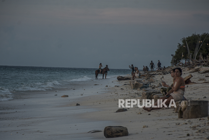 Wisatawan beraktivitas di Pantai Gili Trawangan, Kabupaten Lombok Utara, Nusa Tenggara Barat. Riset kondisi lingkungan di perairan kawasan tiga Gili (Trawangan, Meno dan Air) menunjukkan bebas dari bahaya potensi keracunan ikan Ciguatera.
