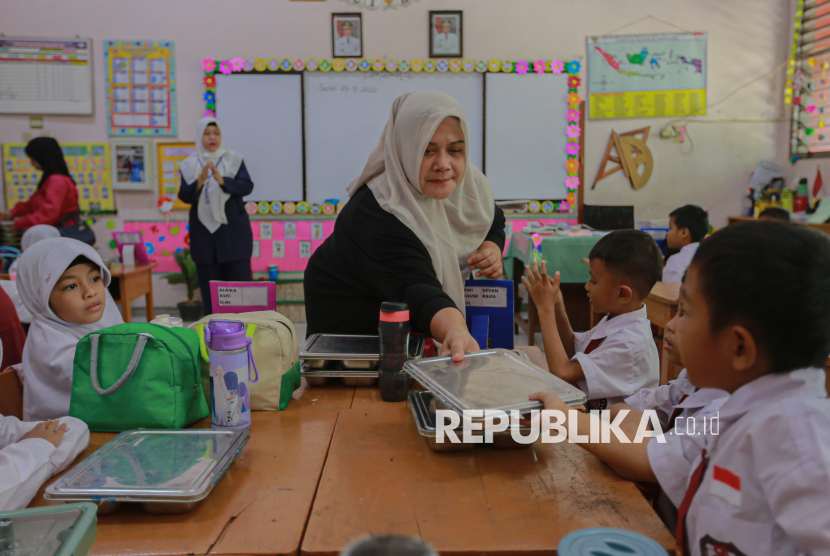 Wali siswa membantu menyiapkan hidangan Makanan Bergizi Gratis (MBG) di SDN Pejaten Barat 01 Pagi, Jakarta Selatan, Senin (29/9/2025).