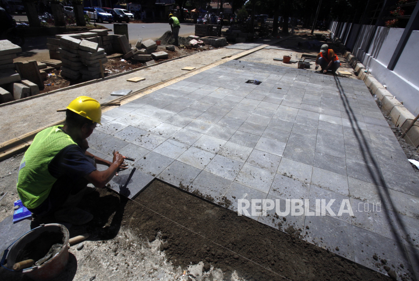 Pekerja menyelesaikan pembangunan pedestarian  di kawasan Stadion Pakansari, Cibinong, Kabupaten Bogor, Jawa Barat, Rabu (2/12/2020). Program pembangunan jalur pedestrian serta penataan drainase tersebut dilakukan untuk memberikan kenyamanan dan keamanan kepada pejalan kaki. 