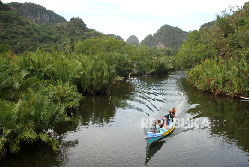 Wisatawan menggunakan perahu saat melitasi Sungai Pute yang berada di dalam kawasan Geopark Maros Pangkep di Kabupaten Maros, Sulawesi Selatan, Ahad (25/6/2023). Geopark Maros Pangkep telah resmi ditetapkan sebagai UNESCO Global Geopark (UGG) berdasarkan keputusan pada Sidang Dewan Eksekutif UNESCO ke-216 di Paris, Prancis pada 24 Mei 2023. 