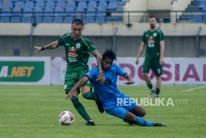 Pesepak bola PSS Sleman Nico Velez (kiri) berebut bola dengan Pesepak bola Persela Lamongan Syahroni (kanan) pada laga lanjutan grup C Piala Menpora 2021 di Stadion Si Jalak harupat, Kabupaten Bandung, Jawa Barat, Ahad (28/3/2021). Pertandingan tersebut berakhir imbang dengan skor kacamata. 