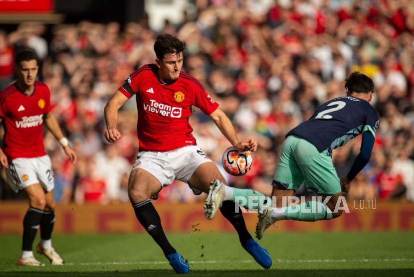 Bek Manchester United Harry Maguire (kiri) saat berebut bola melawan bek Brentord Aaron Hickey. 