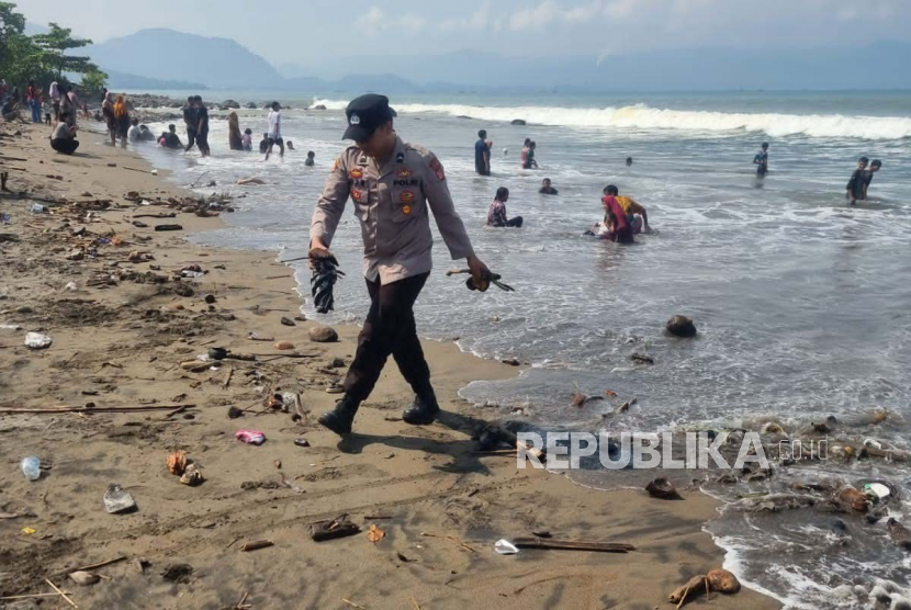 Personel Polres Sukabumi memunguti sampah di kawasan Pantai Kadaka, Kecamatan Cikakak, Kabupaten Sukabumi, Jawa Barat, Rabu (26/4/2023).