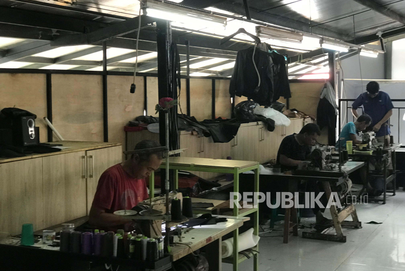 Pengerajin kulit di Astiga Leather tengah melakukan pengerjaan kerajinan di produksi toko yang berada di Garut, Jawa Barat, Kamis (2/5/2024). 