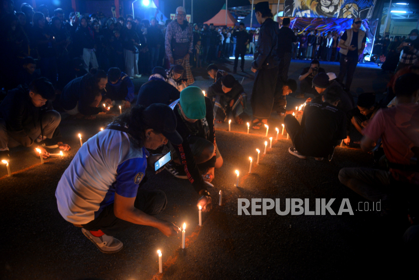 Aremania menyalakan lilin saat malam peringatan setahun tragedi Kanjuruhan di Stadion Kanjuruhan, Malang, Ahad (1/10/2023).