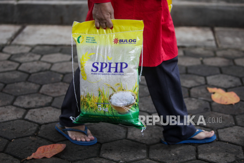 Warga membawa beras saat bazar pasar murah di Kantor Kecamatan Pancoran, Jakarta, Senin (26/2/2024). 
