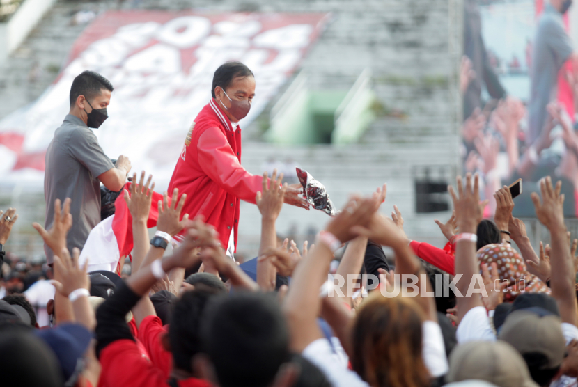 Presiden Joko Widodo (kanan) membagikan kaos saat menghadiri Konser Satu Komando Sapu Lidi di Stadion Gelora 10 November Tambaksari, Surabaya, Jawa Timur, Ahad (21/8/2022). 