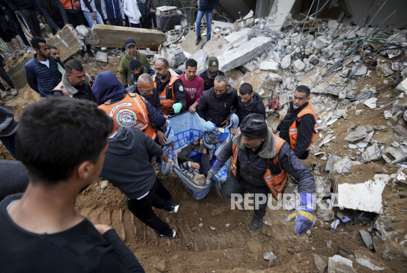 Warga Palestina membawa seseorang yang tewas dalam serangan udara Israel di Deir al Balah, Jalur Gaza, Jumat, (9/2/2024).