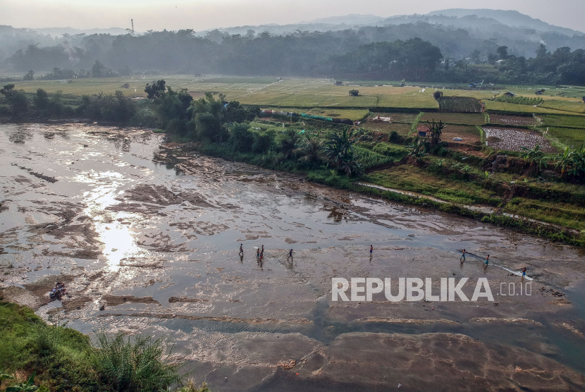 Foto udara warga melintasi dasar sungai Cileungsi yang mengering di Pasir Mukti, Kabupaten Bogor, Jawa Barat. 