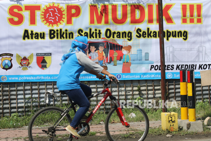 Warga melintas di depan spanduk bertuliskan 'Stop Mudik'. (ilustrasi)