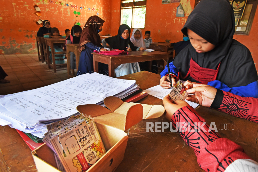 Murid Madrasah Hidayatul Athfal Taktakan menandatangani berkas penerimaan kartu internet gratis untuk Pembelajaran Jarak Jauh (PJJ) 