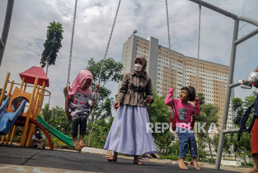 Orang tua mendampingi anaknya bermain di RPTRA Garuda, Cipayung, Jakarta Timur,  Ahad (9/10/2022). Taman tersebut menyediakan  fasilitas taman bermain untuk mendukung perkembangan anak dan memberikan kenyamanan agar bisa berinteraksi dengan seluruh warga dari berbagai kalangan. 