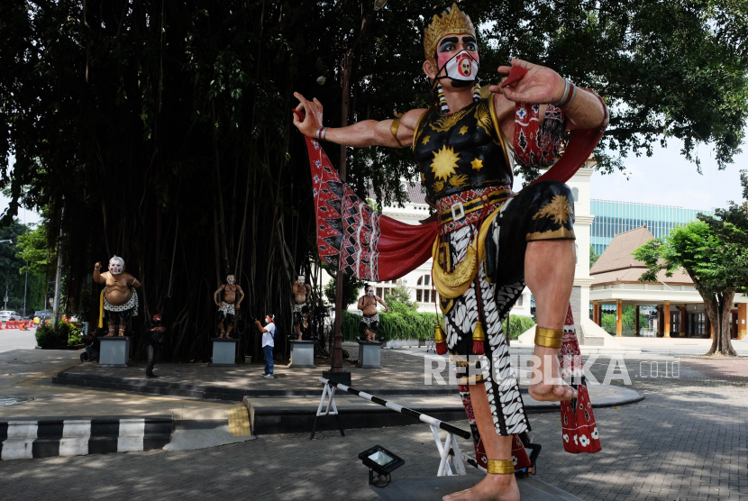 Patung wayang yang dipasangi masker kain di halaman Balai Kota Solo, Jawa Tengah, Ahad (19/4/2020). Pemkot Solo memasang masker pada patung- patung wayang yang ada di wilayah Balai Kota Solo tersebut sebagai salah satu bentuk kampanye penggunaan masker bagi masyarakat guna mencegah penularan COVID-19