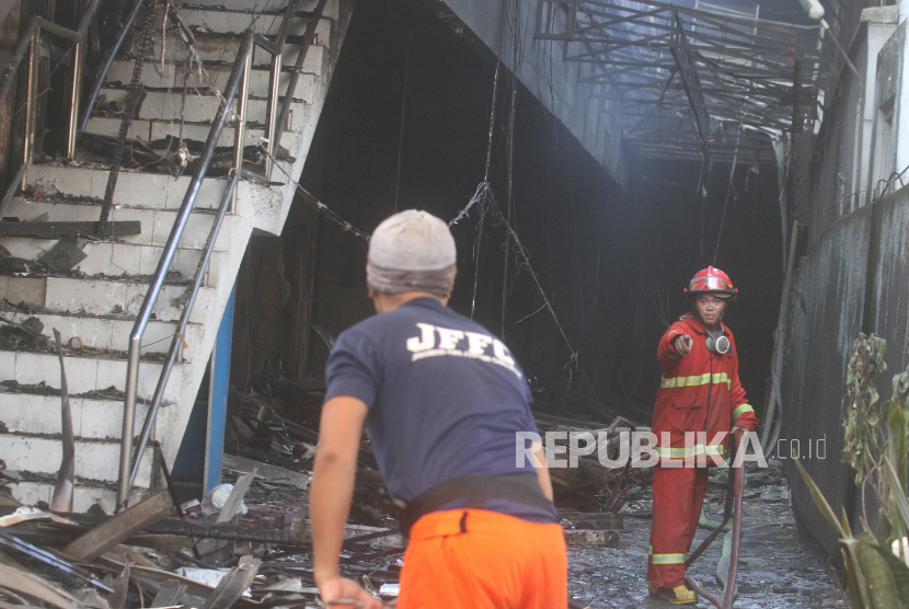 Petugas pemadam kebakaran menarik slang air untuk memadamkan sisa api saat terjadi kebakaran di Malang Plaza, Malang, Jawa Timur, Selasa (2/5/2023). Tidak ada korban jiwa dalam kebakaran yang menghanguskan seluruh gedung pusat perbelanjaan tersebut.   