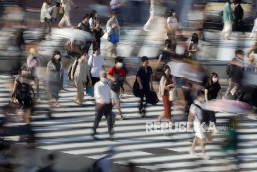 Pejalan kaki yang mengenakan topeng pelindung berjalan di persimpangan jalan di Shibuya, dekat pusat perbelanjaan komunitas mode Shibuya 109, di Tokyo, Jepang, 03 Agustus 2020. Pemerintah Metropolitan Tokyo mengumumkan pada 03 Agustus 2020 258 kasus baru yang dikonfirmasi tentang penyakit coronavirus (COVID-19 ). Ini adalah hari ketujuh berturut-turut menandai lebih dari 200 kasus terdaftar per hari. Jumlah total orang yang terinfeksi di Jepang telah melebihi 40.000. Menurut laporan, 170 dari 258 orang yang terinfeksi adalah orang berusia 20-an dan 30-an. 