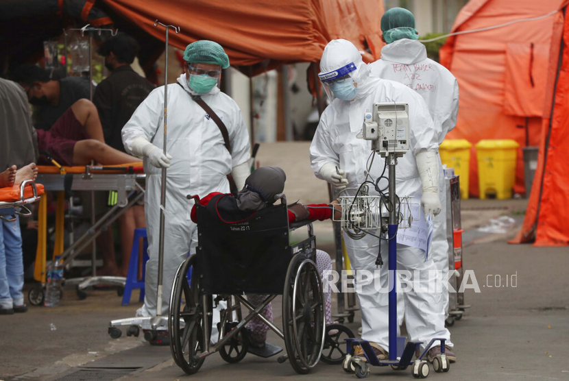 Paramedis merawat orang-orang di tenda darurat yang didirikan untuk menampung lonjakan pasien COVID-19 di sebuah rumah sakit di Bekasi, di pinggiran Jakarta, Indonesia, Sabtu, 10 Juli 2021.