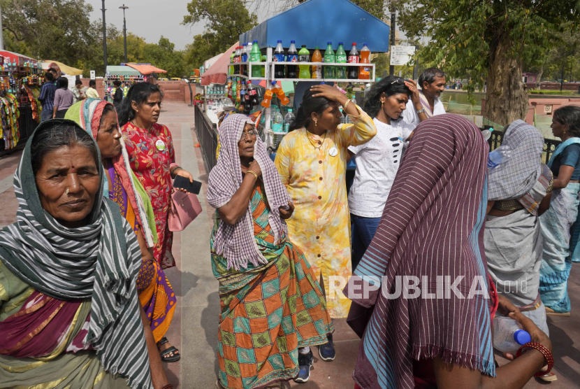 Wisatawan lokal yang kelelahan akibat gelombang panas membeli botol air minum, di New Delhi, India, Selasa (18/6/2024). 