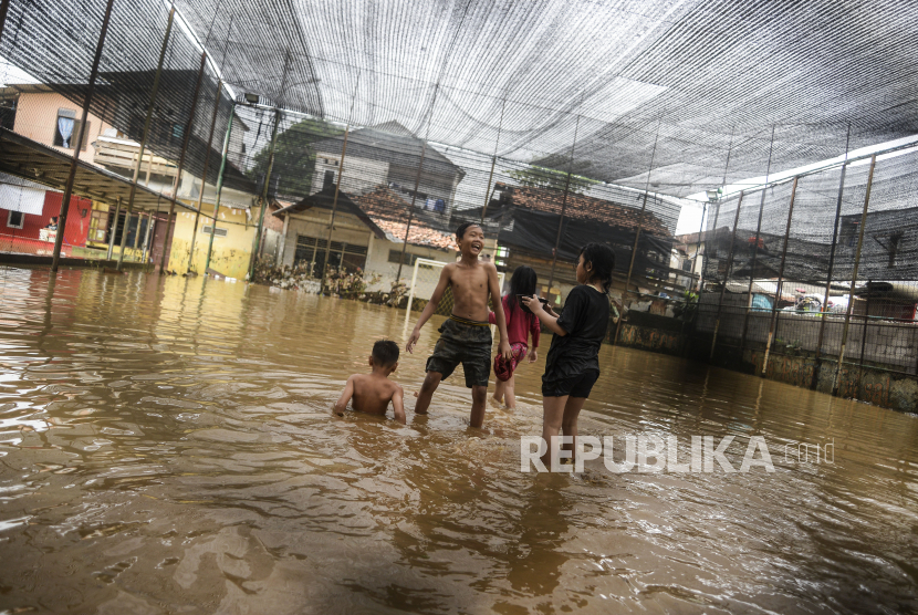 Anak-anak bermain saat terjadi banjir di kawasan Rawajati, Jakarta, Senin (10/10/2022). BPBD DKI memastikan sudah tidak ada lagi pengungsi banjir di Jakarta.