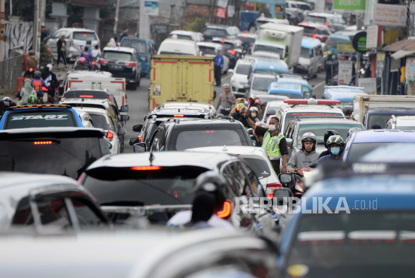 Warga mengatur lalu lintas saat terjadi kemacetan di kawasan Cisarua, Kabupaten Bogor, Jawa Barat.