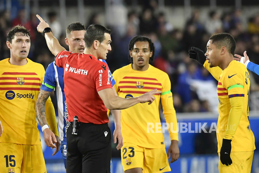 Players argue with referee Juan Martinez Munuera during the La Liga soccer match between Deportivo Alaves and FC Barcelona at the Medizorrosa stadium in Vitoria, Spain, Saturday, Feb. 3, 2024.  