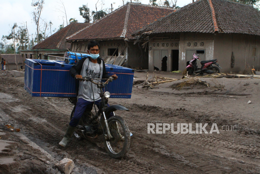 Warga mengangkut barang yang tersisa dari rumahnya yang hancur akibat diterjang material vulkanik gunung Semeru di dusun Umbulan, Pronojiwo, Lumajang, Jawa Timur, Rabu (8/12/2021) Pemerintah berencana merelokasi  sekitar 2.000 rumah warga yang terdampak letusan gunung Semeru. 