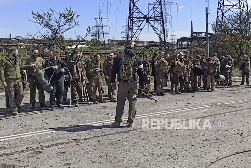 Dalam foto yang diambil dari video yang dirilis oleh Layanan Pers Kementerian Pertahanan Rusia pada hari Rabu, 18 Mei 2022, prajurit Ukraina berdiri di depan seorang prajurit Rusia setelah mereka meninggalkan pabrik baja Azovstal yang terkepung di Mariupol, Ukraina.