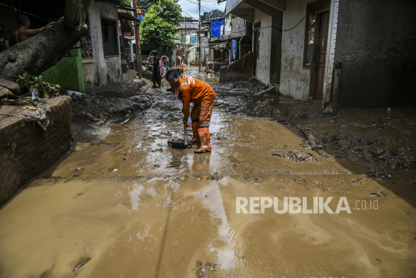 Petugas kebersihan bersama warga membersihkan endapan lumpur sisa banjir di kawasan Pejaten Timur, Pasar Minggu, Jakarta, Selasa (9/2/2021). Banjir yang melanda permukiman warga di kawasan tersebut berangsur surut, dan warga mulai membersihkan rumah dari endapan lumpur sisa banjir. 