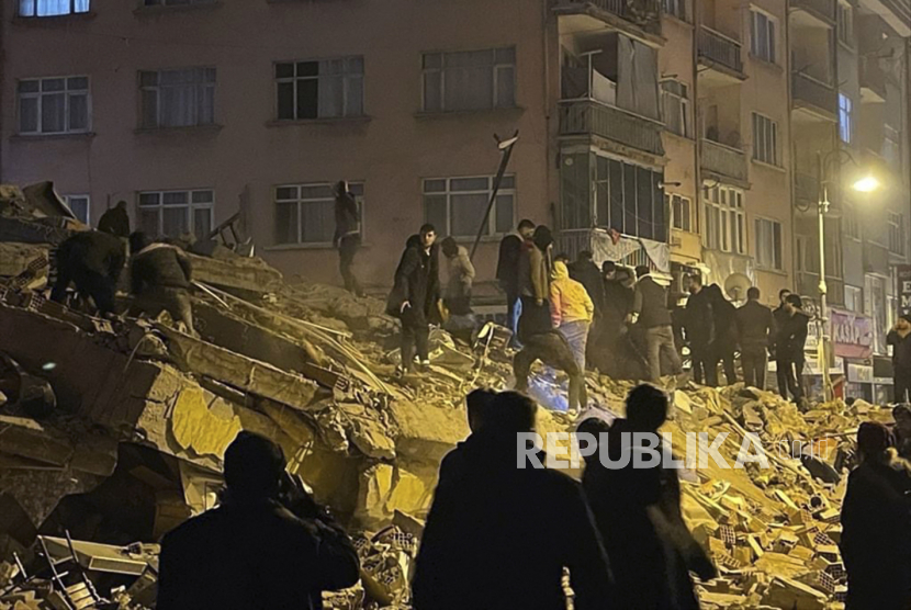 Warga berusaha menolong korban bangunan yang roboh akibat diguncang gempa di Pazarcik, Turki, Senin (6/2/2023). Gempa besar berkekuatan 7,8 mengguncang tenggara Turki Senin (6/2/2023) pagi WIB. Kerusakan akibat gempa dilaporkan terjadi di beberapa Provinsi Turki, dan tim penyelamat diterjunkan untuk menolong korban gempa.