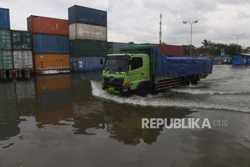 Sebuah truk melintasi banjir rob di Pelabuhan Sunda Kelapa, Jakarta, Selasa (7/12/2021). Akibat banjir rob di pelabuhan tersebut sejumlah aktivitas bongkar muat barang menjadi terhenti. 