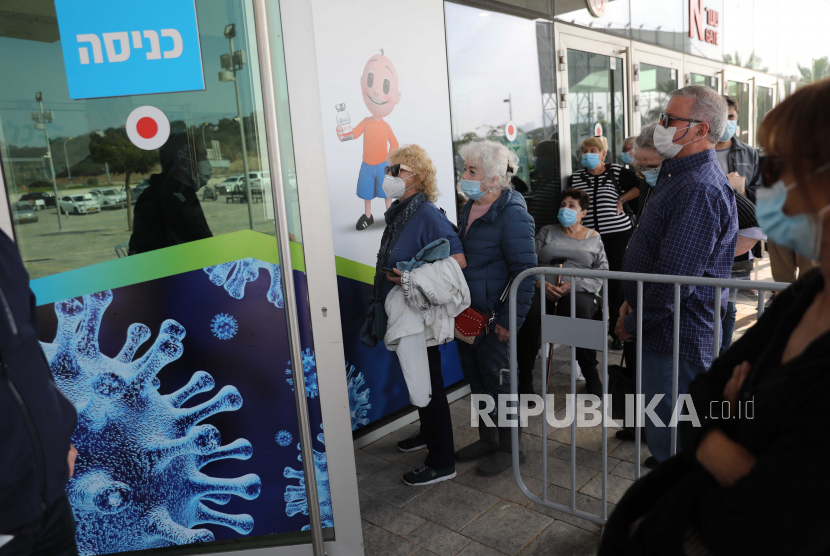  Orang-orang yang mengantri untuk mendapatkan dosis pertama vaksin virus corona, di Heichal Shlomo Sports Arena yang berubah menjadi pusat vaksinasi besar-besaran di Tel Aviv, Israel, 22 Desember 2020.  Israel akan memberlakukan karantina wilayah (lockdown) berskala nasional ketiga.