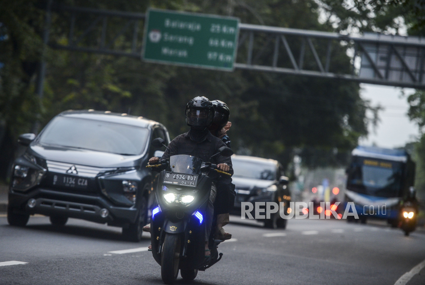 Pengendara motor menggunakan masker saat melintasi Jalan Daan Mogot, Kota Tangerang. Ilustrasi