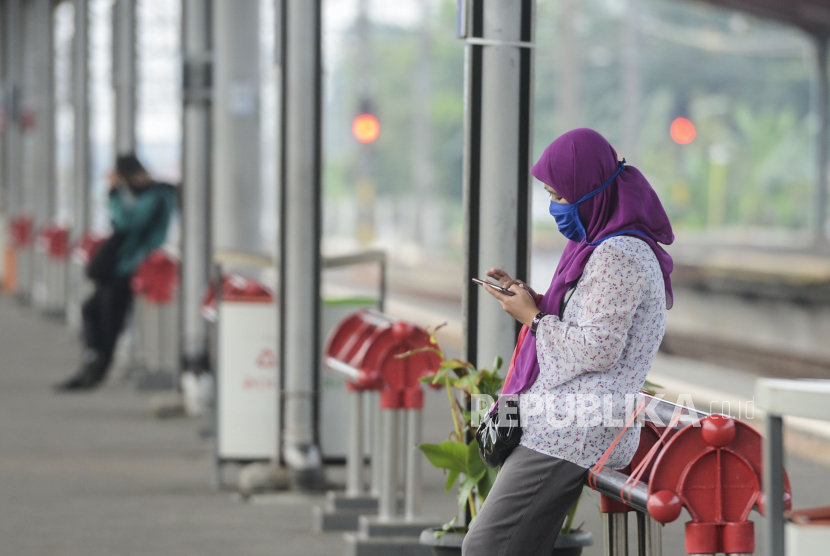 Sejumlah penumpang menunggu KRL Commuter Line di Stasiun Depok, Jawa Barat, Rabu (15/4). Penumpang KRL tujuan Depok terpantau berkurang pada Hari pertama pemberlakuan Pembatasan Sosial Berskala Besar (PSBB) di Kota Depok