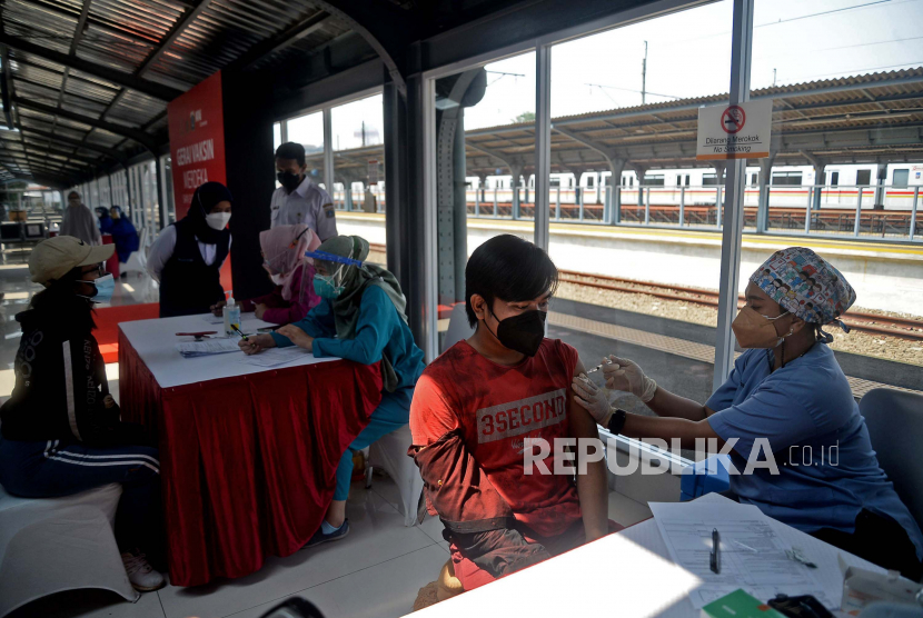 Tenaga kesehatan menyuntikkan vaksin COVID-19 kepada warga di stasiun kereta api. 