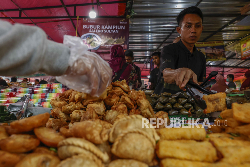  Seorang penjual makanan buka puasa melayani pelanggannya di pasar Ramadhan yang menjual makanan ringan  untuk berbuka puasa, dikenal sebagai takjil di Jakarta, Rabu (29/3/2023). Muhammadiyah Prihatin Sampah Makanan Ketika Ramadhan Meningkat
