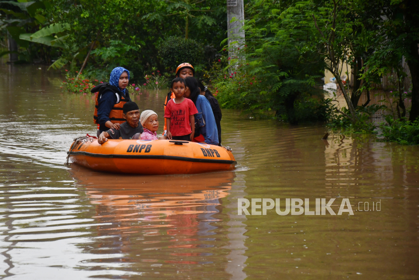 Petugas Badan Penanggulangan Bencana Daerah (BPBD) dan Dinas Kesehatan mengevakuasi warga menggunakan perahu karet saat banjir (ilustrasi).