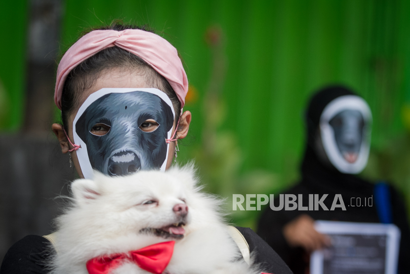 Relawan komunitas pecinta hewan melakukan aksi diam dengan topeng anjing di Solo, Jawa Tengah. Walkot Solo Gibran sebut para pedagang daging anjing cukup kooperatif mematuhi SE.