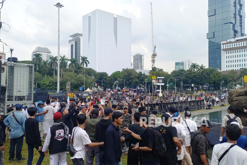 Massa aksi saling lempar dengan massa lainnya yang melakukan aksi di Patung Kuda, Jalan Medan Merdeka Barat, Kecamatan Gambir, Jakarta Pusat, Jumat (19/4/2024). 